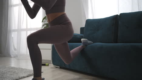 Sexy-Fitness-Model-Trainiert-Im-Wohnzimmer-Und-Macht-Kniebeugen,-Nahaufnahme-Des-Unteren-Teils-Des-Weiblichen-Körpers,-Fitnessstudio-Häschen-Workout-Zu-Hause